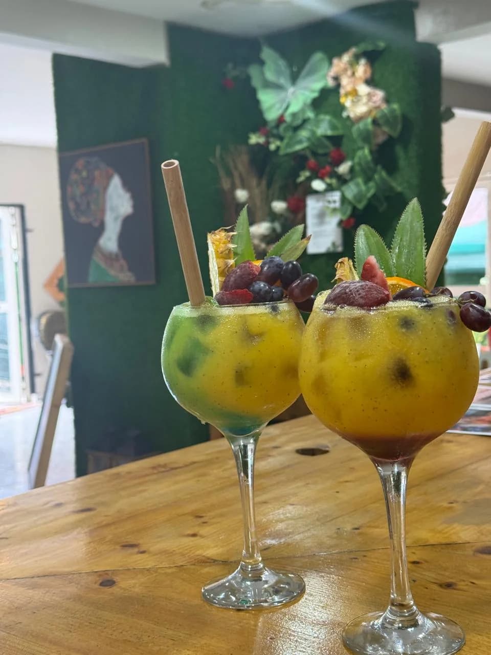 Deux cocktails de jus maison, garnis de fruits et servis dans leurs verres à pied